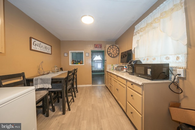 4990 W Thompson St, Philadelphia, PA 19131 - kitchen with light wood-style floors, light countertops, baseboards, and black microwave