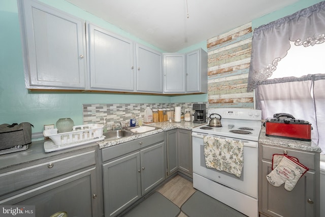 4990 W Thompson St, Philadelphia, PA 19131 - kitchen with a sink, light countertops, gray cabinets, light wood-style flooring, and electric range