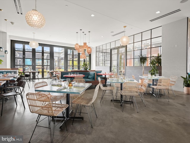 dining area featuring visible vents, floor to ceiling windows, and finished concrete floors