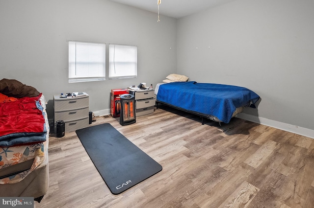 bedroom with baseboards and wood finished floors