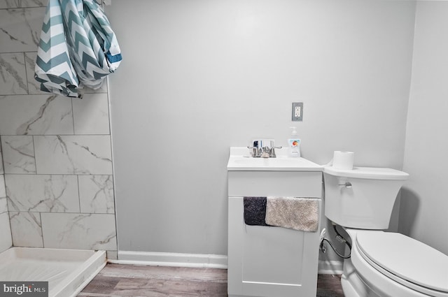 full bathroom with a shower stall, vanity, toilet, wood finished floors, and baseboards