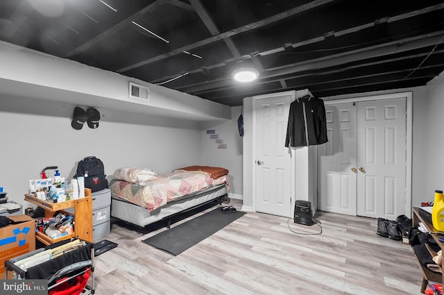 bedroom featuring wood finished floors, a closet, and visible vents