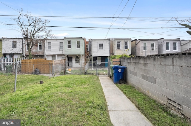 exterior space featuring a front yard, a gate, fence, and a residential view