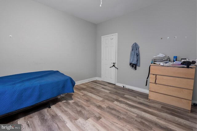 bedroom featuring wood finished floors and baseboards