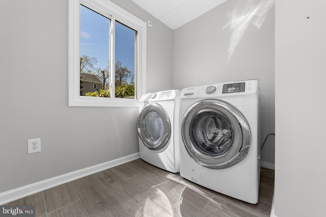 laundry area featuring wood finished floors, independent washer and dryer, laundry area, and baseboards