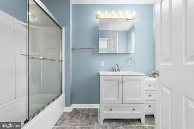 bathroom with combined bath / shower with glass door, visible vents, vanity, and baseboards