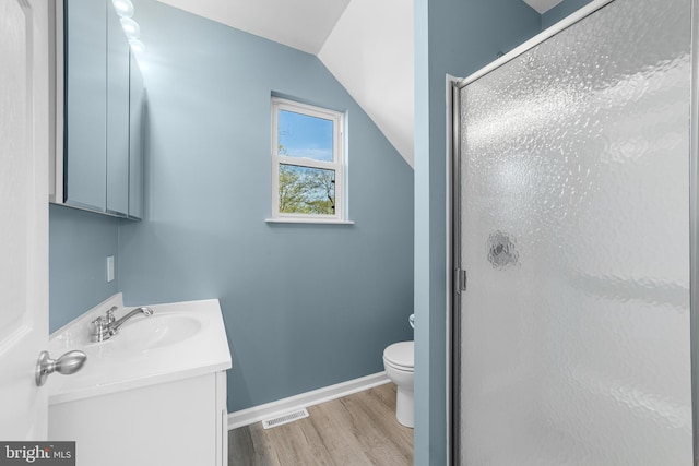 full bath with a shower stall, visible vents, toilet, wood finished floors, and vanity