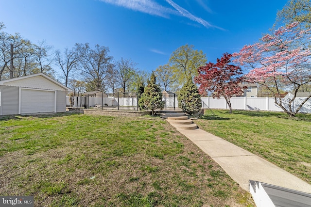 view of yard with a detached garage, fence, and an outdoor structure