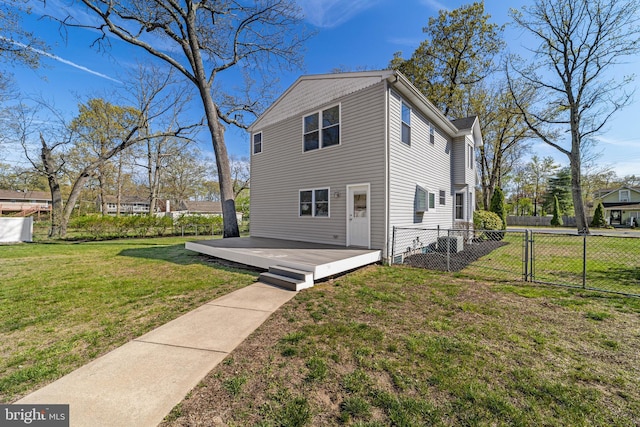 back of house featuring a deck, fence, a gate, and a yard