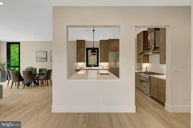 1853 Massachusetts Ave, Mclean, VA 22101 - kitchen featuring wall chimney range hood, premium appliances, modern cabinets, a sink, and light wood-style flooring