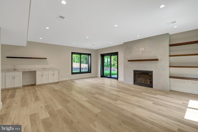 1853 Massachusetts Ave, Mclean, VA 22101 - unfurnished living room with light wood finished floors, a fireplace, a sink, recessed lighting, and baseboards