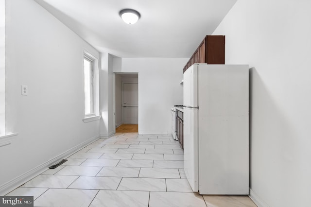 kitchen with baseboards and freestanding refrigerator