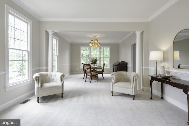 sitting room with decorative columns, plenty of natural light, light colored carpet, baseboards, and crown molding