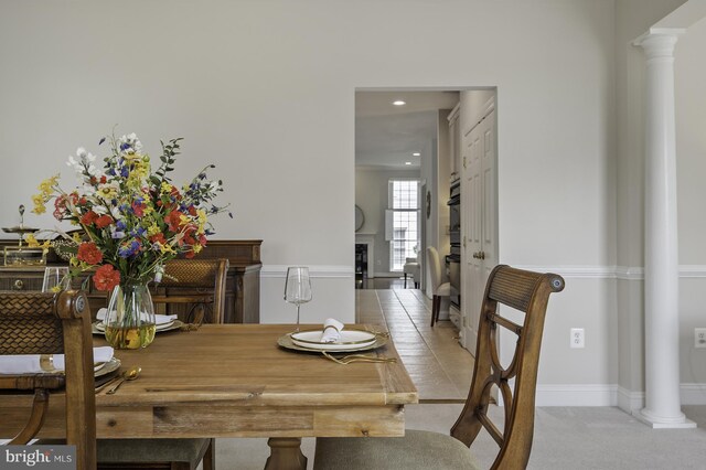 dining room featuring decorative columns, light colored carpet, and recessed lighting