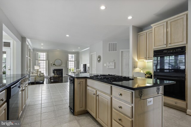 kitchen featuring black appliances, dark countertops, a glass covered fireplace, recessed lighting, and light brown cabinets
