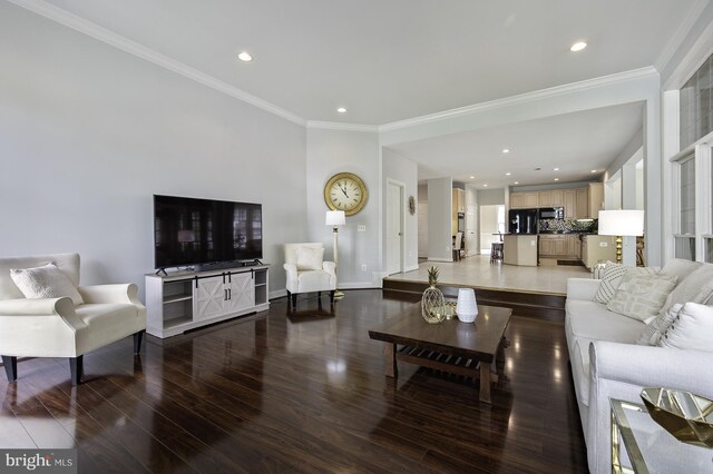 living room featuring wood finished floors, ornamental molding, baseboards, and recessed lighting