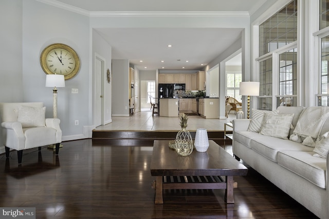 living area with baseboards, light wood-style floors, and ornamental molding