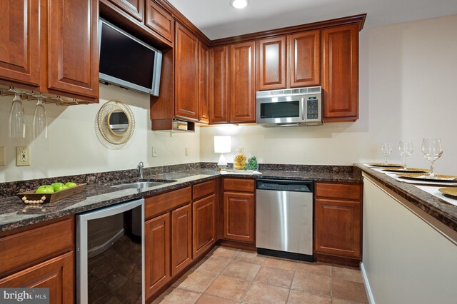 kitchen featuring stainless steel appliances, wine cooler, a sink, dark stone counters, and recessed lighting