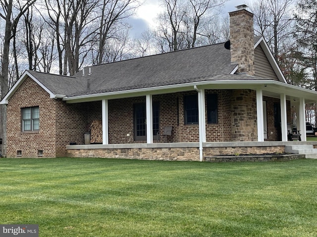 view of property exterior featuring roof with shingles, a yard, and brick siding