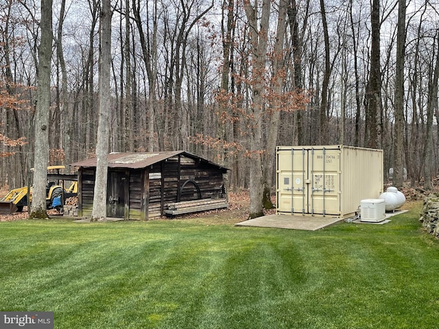 view of outbuilding featuring a view of trees and an outdoor structure
