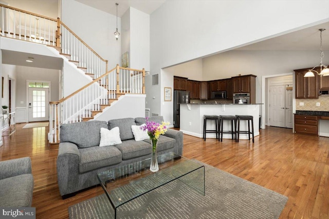 7135 Hills Ln, Warrenton, VA 20187 - living area featuring a high ceiling, stairway, and light wood-style floors