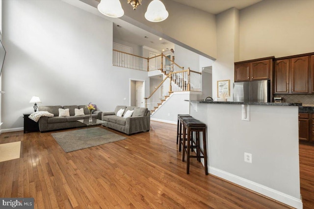 7135 Hills Ln, Warrenton, VA 20187 - living room with a towering ceiling, stairs, wood finished floors, and baseboards