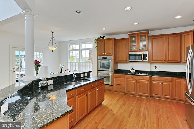 kitchen with recessed lighting, a sink, brown cabinets, stainless steel appliances, and ornate columns