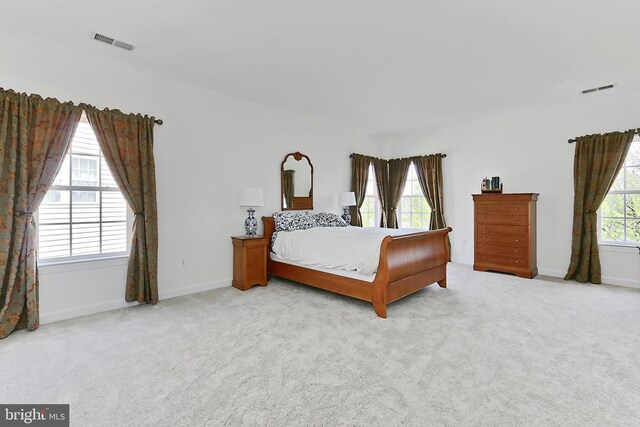 bedroom featuring visible vents, baseboards, and light carpet
