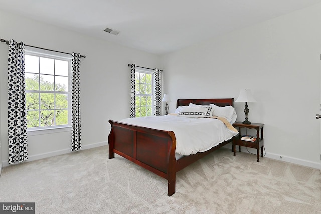 carpeted bedroom with visible vents and baseboards