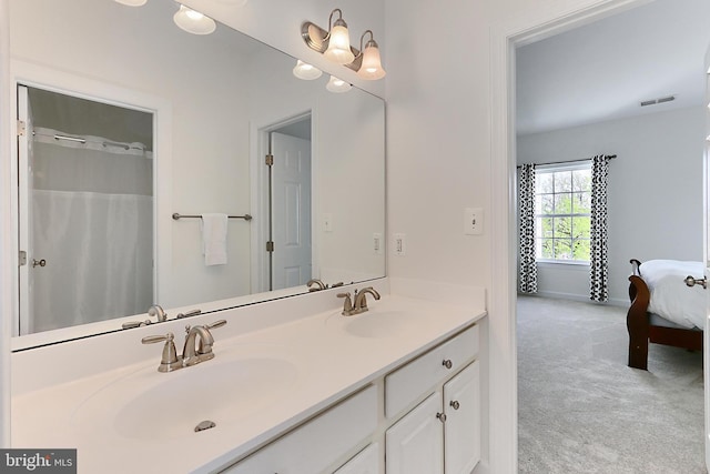 bathroom featuring double vanity, a sink, baseboards, and visible vents