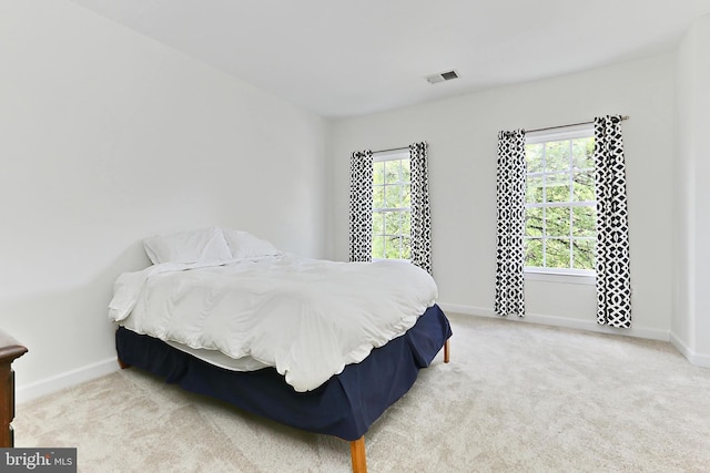 carpeted bedroom featuring visible vents and baseboards