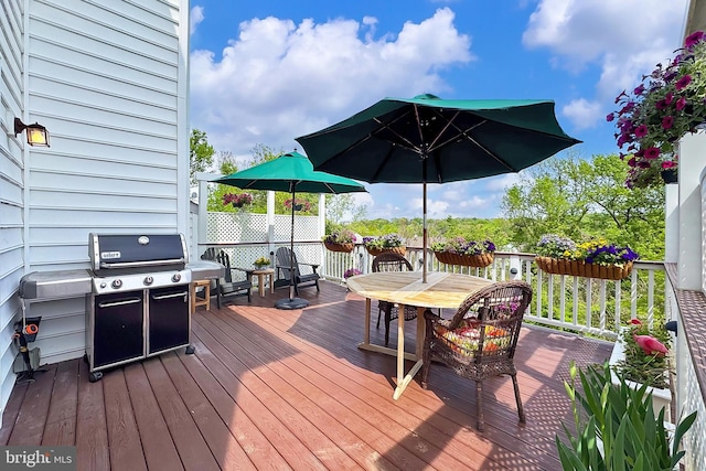 wooden deck with outdoor dining area and grilling area