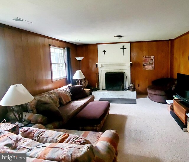 living room with a fireplace, wooden walls, and carpet