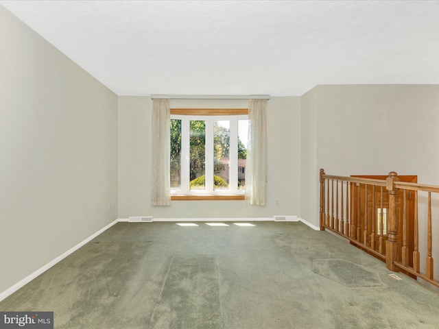 spare room with baseboards, visible vents, and carpet