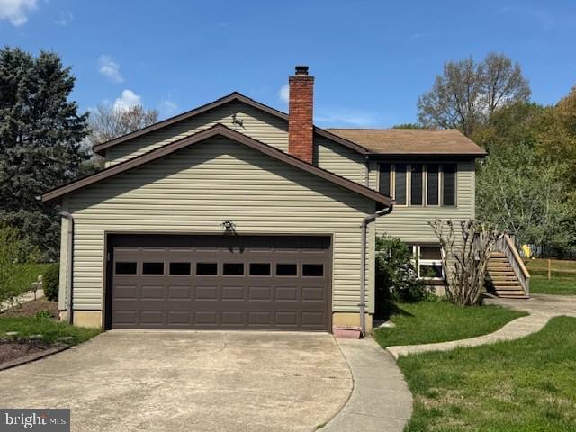 view of front facade with a chimney, a front yard, a garage, stairway, and concrete driveway