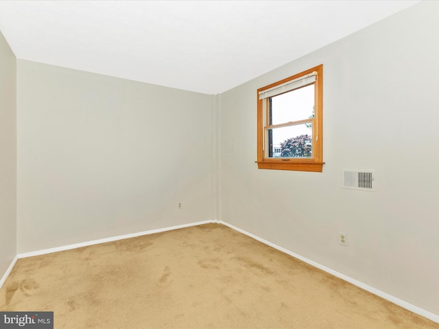 spare room featuring baseboards, carpet flooring, and visible vents