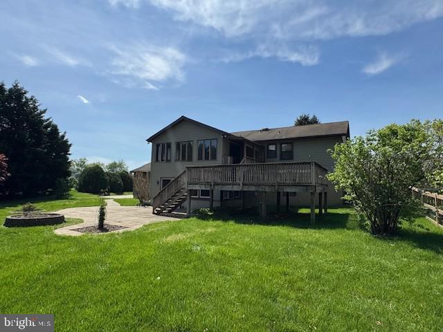 back of property with a lawn, stairs, a patio area, and a deck