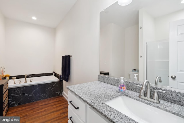 full bath featuring a bath, recessed lighting, vanity, and wood finished floors