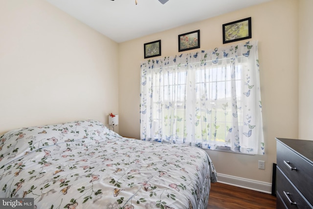 bedroom featuring dark wood-style flooring, multiple windows, baseboards, and ceiling fan