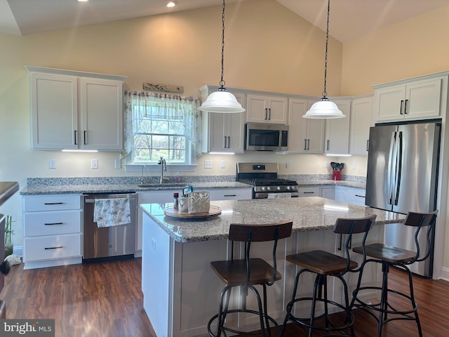 kitchen with high vaulted ceiling, a center island, white cabinets, stainless steel appliances, and a sink