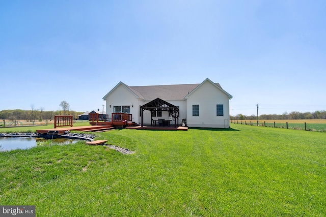back of house featuring a gazebo, a wooden deck, and a lawn