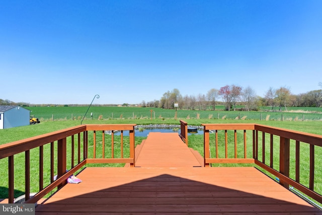 wooden deck featuring a yard and a rural view