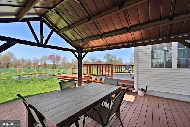 deck featuring a gazebo, outdoor dining area, and a yard