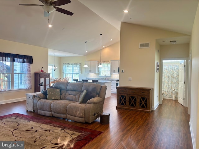 living area with high vaulted ceiling, ceiling fan, visible vents, and dark wood-style flooring