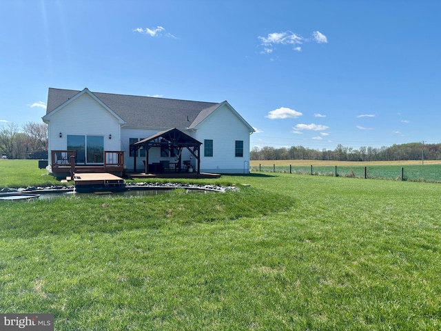 rear view of house featuring a gazebo, a yard, and a wooden deck