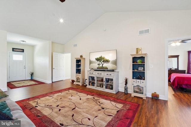 living area featuring high vaulted ceiling, ceiling fan, visible vents, and wood finished floors