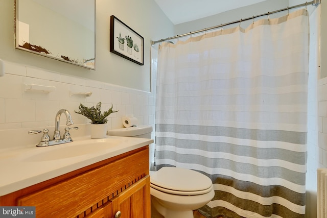 bathroom with radiator, toilet, vanity, and curtained shower