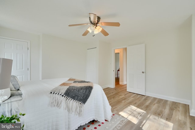 bedroom featuring baseboards, wood finished floors, a closet, and ceiling fan