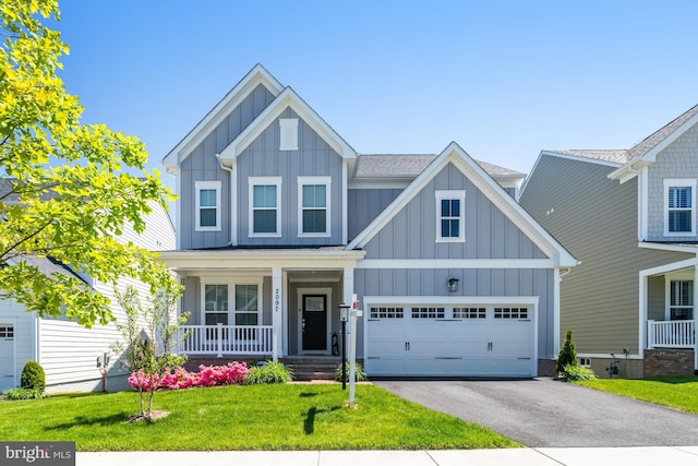 craftsman inspired home featuring board and batten siding, covered porch, driveway, a front lawn, and a shingled roof