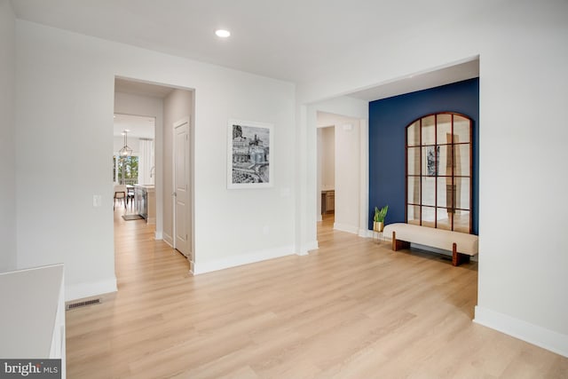 spare room with baseboards, visible vents, and light wood finished floors